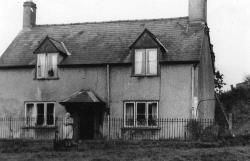 Elizabeth Tipper at the gate of the farmhouse on the Norman Hill estate, c1961.